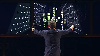 Man demonstrates rummage by controlling two large rectangles on a triptych of computer monitors using his arms outstretched to his side